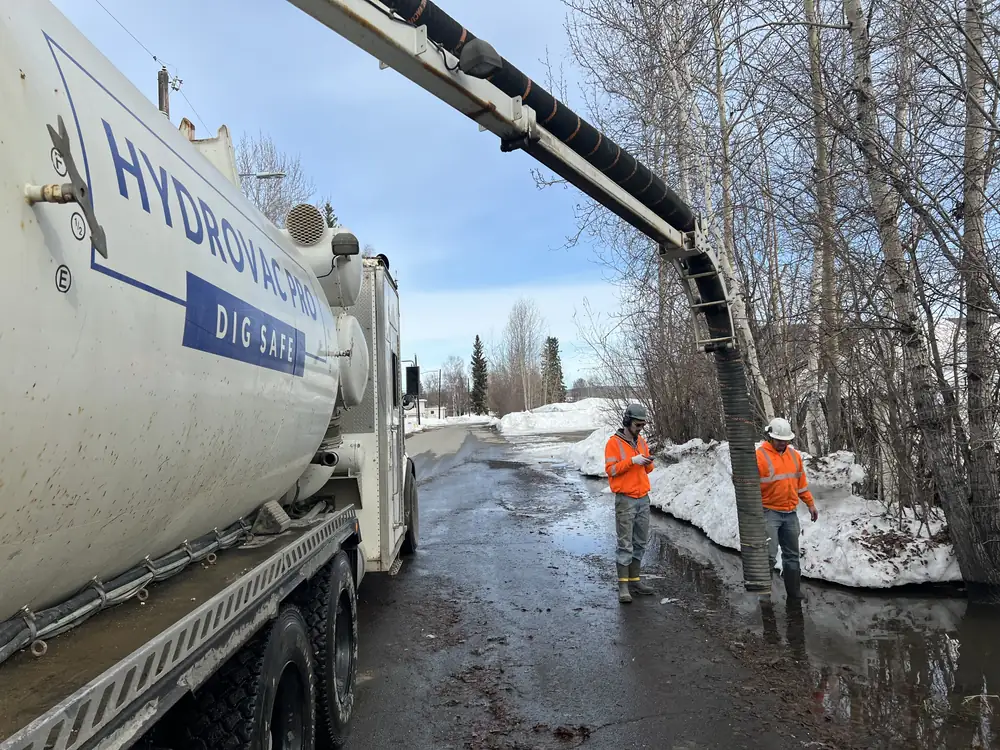 Hydrovac Pro truck working with boom deployed while a crew member operates the dig